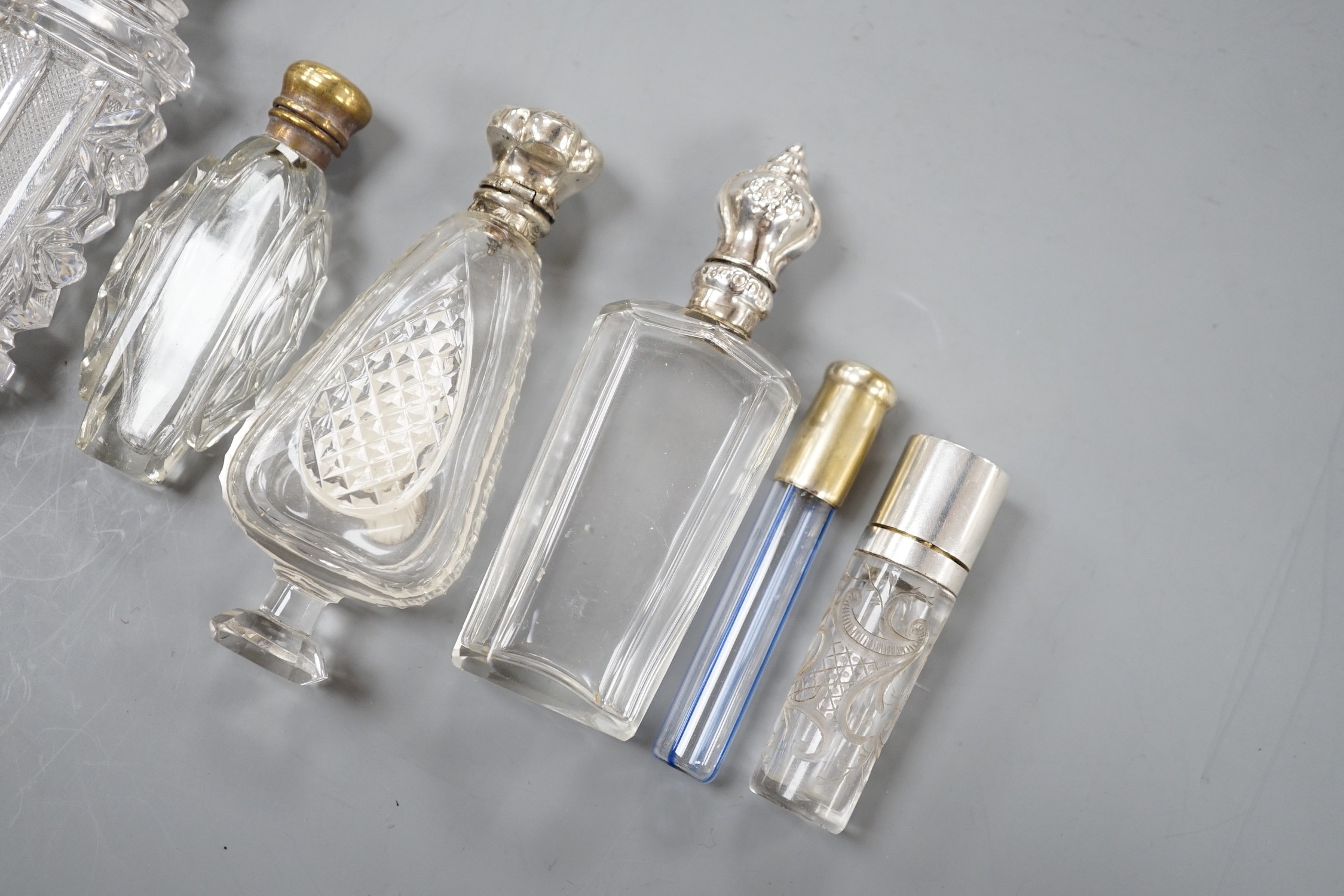 Nine assorted late 19th/early 20th century white or gilt white metal mounted glass scent bottles, including Austro-Hungarian gilt white metal and enamel mounted cylindrical scent by George Adam Scheid, largest 17.2cm.